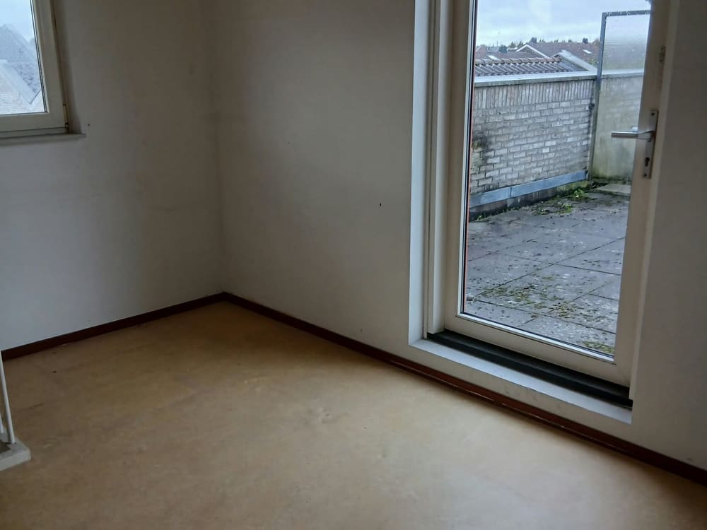 Lege kamer met groot raam en veel daglicht na de woningontruiming