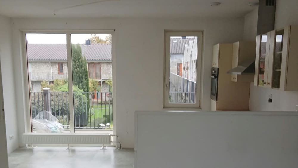 Leeggehaalde en bezemschoon opgeleverde woonkamer met open keuken in Almere Buiten